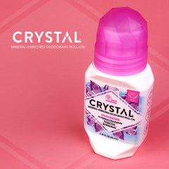 Crystal mineral enriched deodorant roll on bottle against a pink backdrop