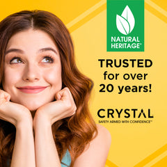 Smiling woman on a yellow backdrop beside a lineup of Crystal deodorants with Natural Heritage branding