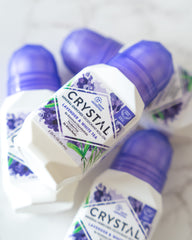 Close up of Crystal Lavender White Tea deodorant bottle with purple caps and floral label