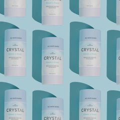 Patterned display of CRYSTAL mineral deodorant bottles on a blue background