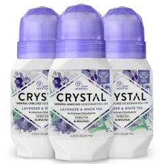 Four Crystal deodorant roll ons with lavender labels and purple caps grouped together