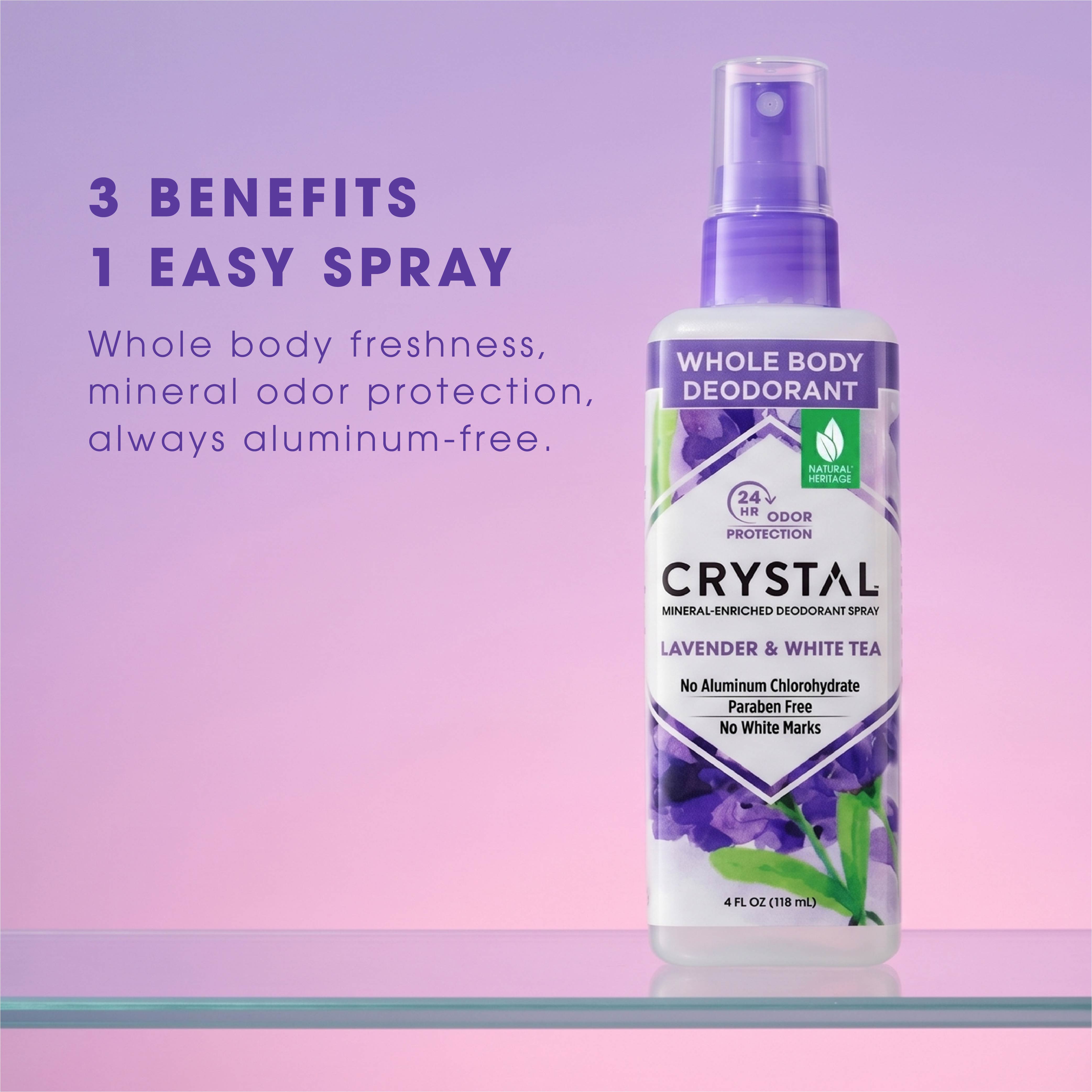 Crystal whole body deodorant spray bottle with lavender and white tea flavor on a pink and purple gradient background.