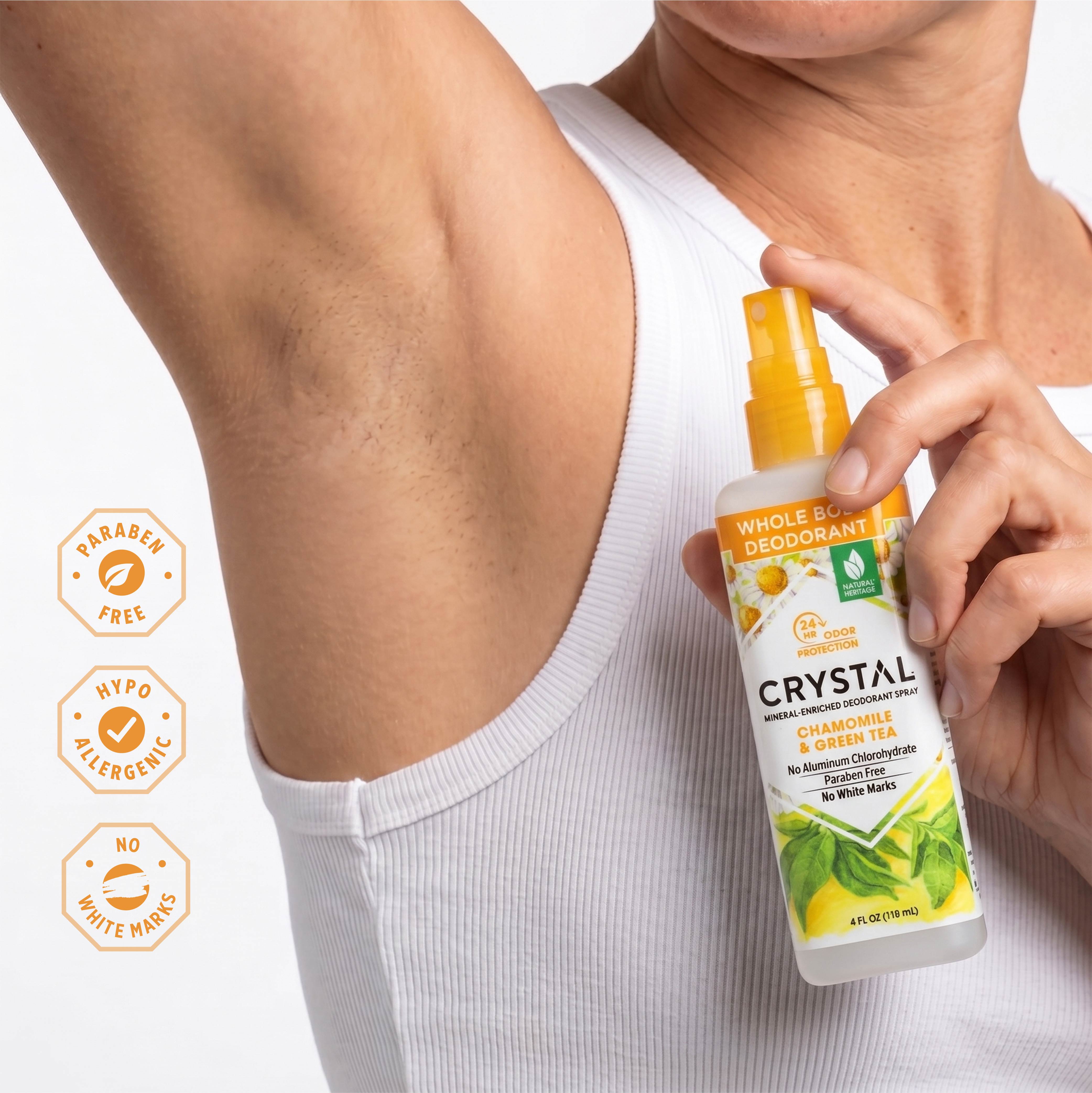 Person applying Crystal Whole Blends deodorant spray to armpit with product details on a white background