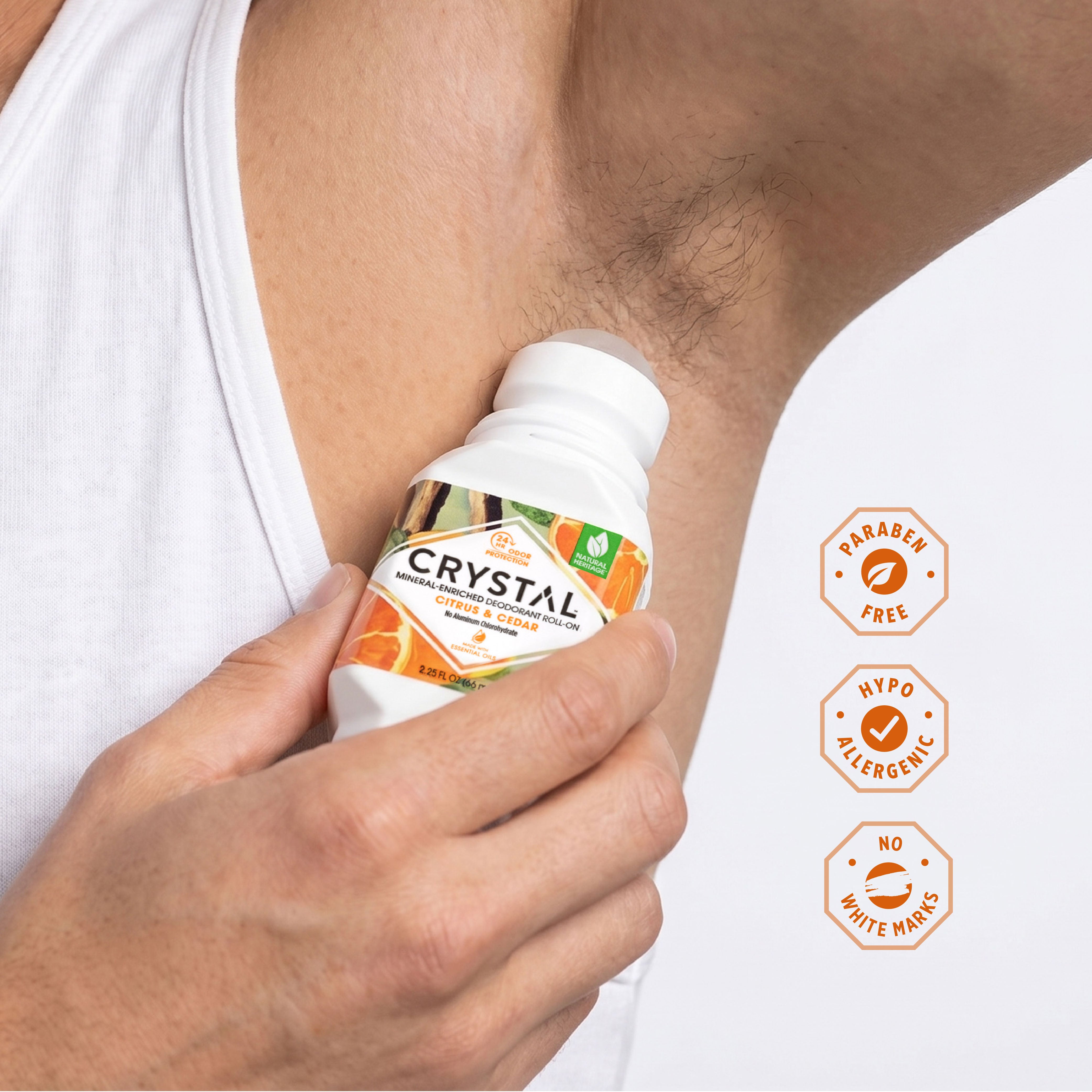 Person applying deodorant 'Crystal' to their armpit with product features highlighted.
