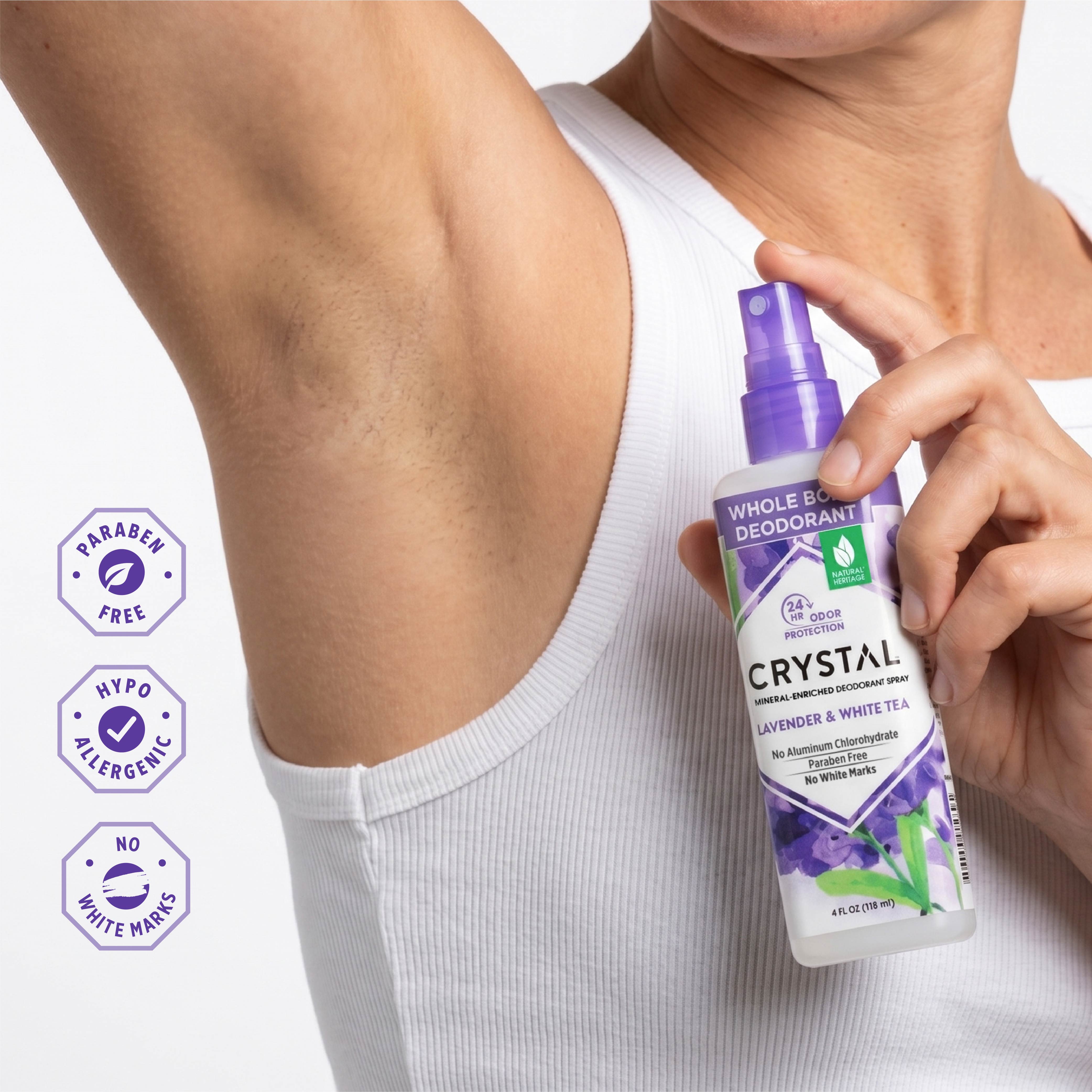 Person holding a bottle of Crystal Whole Body Deodorant with product details on a white background