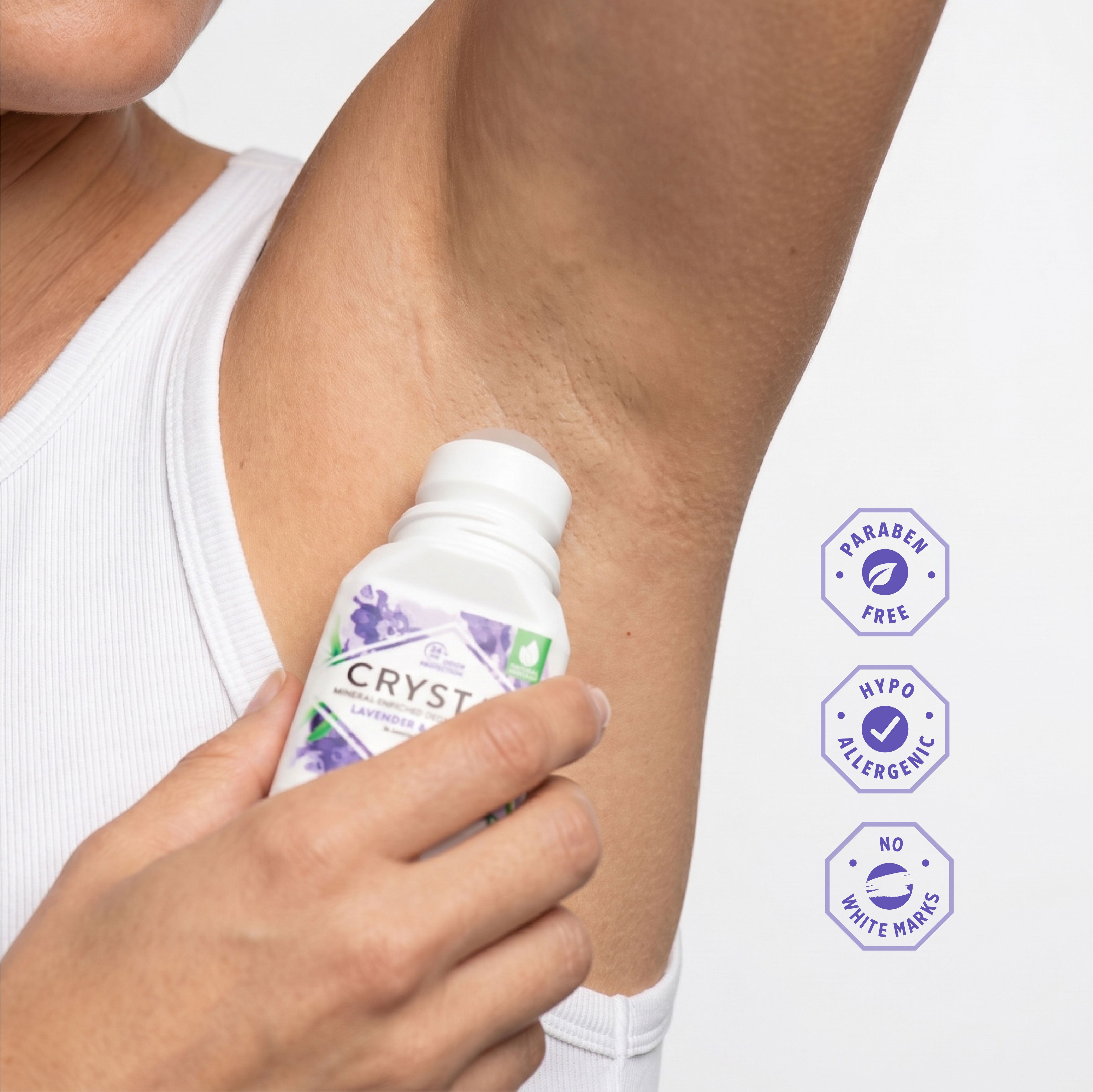 Person applying Crystl deodorant to their arm with product details on a white background
