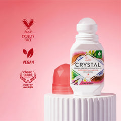 Crystal deodorant roll-on bottle with labels indicating cruelty-free, vegan, and clean label on a pink background.