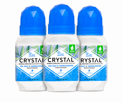 Three bottles of Sea Salt & Sandalwood Crystal deodorant roll-on with blue caps on a white background