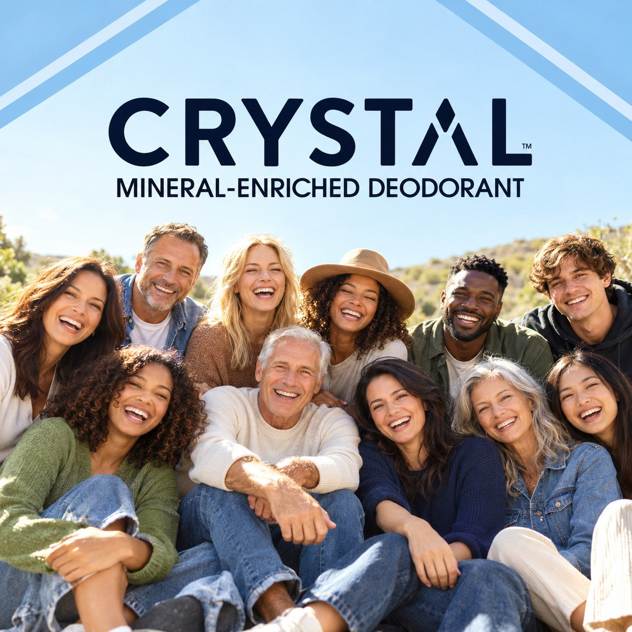 A smiling group of people outdoors beneath the CRYSTAL Mineral-Enriched Deodorant wordmark